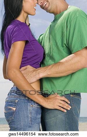 Side profile of a young couple embracing each other View Large Photo Image Picture - Side profile of a young couple embracing each other. Fotosearch