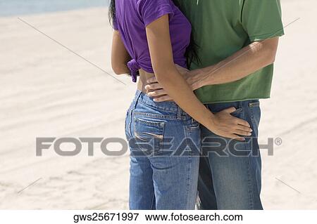 Side profile of a young couple embracing each other on the beach View Large Photo Image Stock Photo - Side profile of a young couple embracing each other on the beach. Fotosearch