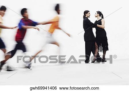 Side profile of a young couple tangoing with three boys running in front of them View Large Photo Image Stock Photograph - Side profile of a young couple tangoing with three boys running in front of them. Fotosearch