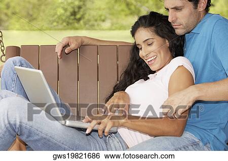 Side profile of a young woman and a mid adult man using a laptop View Large Photo Image Stock Photograph - Side profile of a young woman and a mid adult man using a laptop. Fotosearch