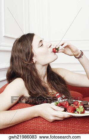 Side profile of a young woman eating a strawberry View Large Photo Image Stock Image - Side profile of a young woman eating a strawberry. Fotosearch