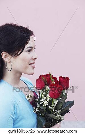 Side profile of a young woman holding a bouquet of flowers View Large Photo Image Stock Photography - Side profile of a young woman holding a bouquet of flowers. Fotosearch