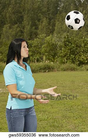 Side profile of a young woman playing with a soccer ball View Large Photo Image Stock Photograph - Side profile of a young woman playing with a soccer ball. Fotosearch