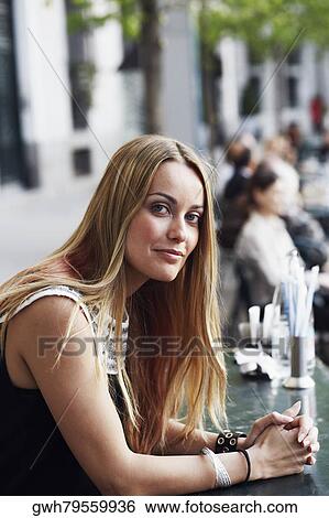 Side profile of a young woman sitting at a sidewalk cafe View Large Photo Image Stock Photograph - Side profile of a young woman sitting at a sidewalk cafe . Fotosearch
