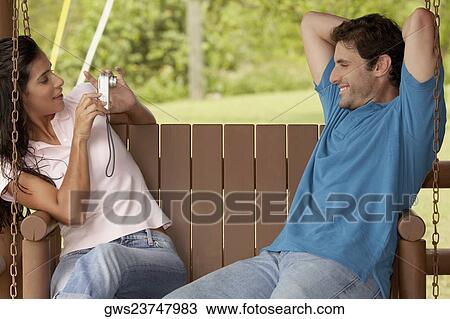 Side profile of a young woman photographing a mid adult man View Large Photo Image Stock Image - Side profile of a young woman photographing a mid adult man. Fotosearch
