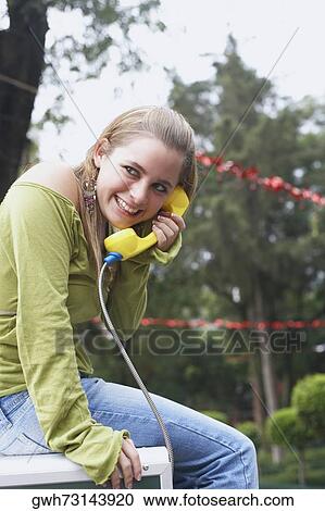 Side profile of a young woman talking on the telephone View Large Photo Image Stock Image - Side profile of a young woman talking on the telephone. Fotosearch