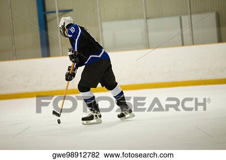 Side profile of an ice hockey player playing ice hockey View Large Photo Image Stock Image - Side profile of an ice hockey player playing ice hockey. Fotosearch