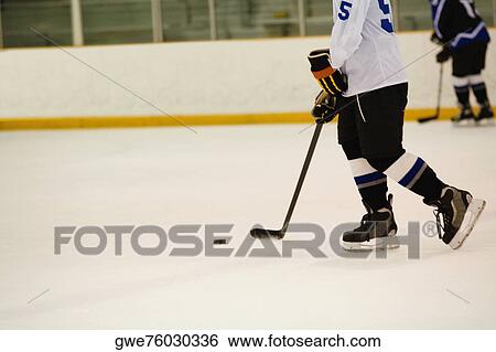 Stock Photograph - Side profile of an ice hockey player playing ice hockey. Fotosearch