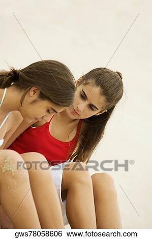 Side profile of two girls sitting together View Large Photo Image Stock Photograph - Side profile of two girls sitting together. Fotosearch