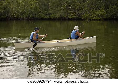Side profile of two mid adult men canoeing View Large Photo Image Picture - Side profile of two mid adult men canoeing. Fotosearch