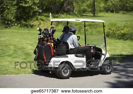 Side profile of two people sitting in a golf cart View Large Photo Image Stock Photo - Side profile of two people sitting in a golf cart. Fotosearch