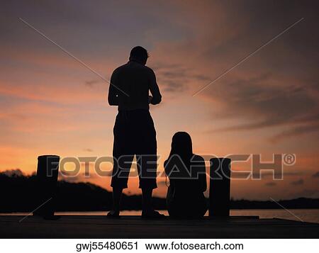 Silhouette of a man and a woman on a pier View Large Photo Image Stock Image - Silhouette of a man and a woman on a pier. Fotosearch
