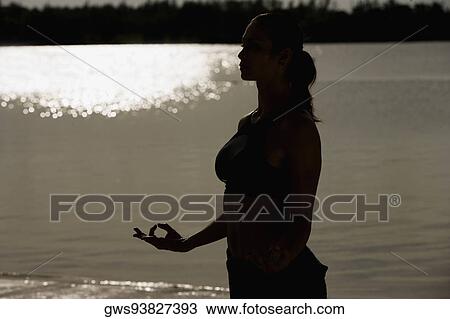 Silhouette of a mid adult woman meditating on the beach View Large Photo Image Stock Image - Silhouette of a mid adult woman meditating on the beach. Fotosearch