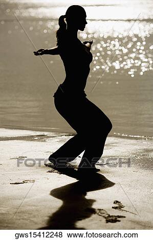Silhouette of a mid adult woman exercising on the beach View Large Photo Image Stock Photo - Silhouette of a mid adult woman exercising on the beach. Fotosearch