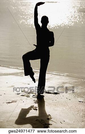 Silhouette of a mid adult woman exercising on the beach View Large Photo Image Stock Photo - Silhouette of a mid adult woman exercising on the beach. Fotosearch