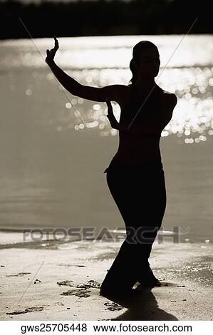 Silhouette of a mid adult woman exercising on the beach View Large Photo Image Stock Photo - Silhouette of a mid adult woman exercising on the beach. Fotosearch