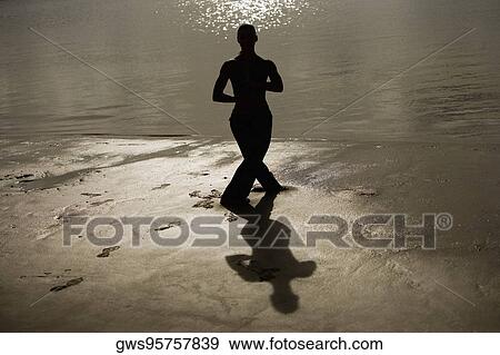 Silhouette of a mid adult woman exercising on the beach View Large Photo Image Stock Photo - Silhouette of a mid adult woman exercising on the beach. Fotosearch