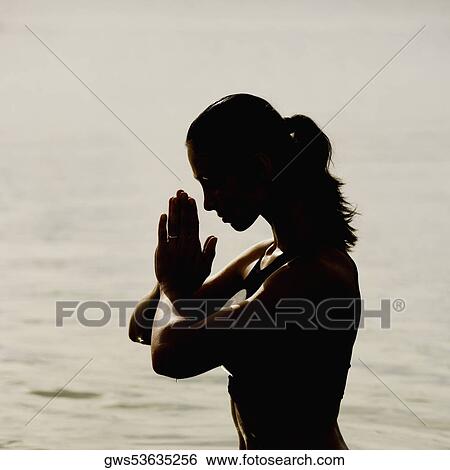 Silhouette of a mid adult woman meditating in water View Large Photo Image Stock Photograph - Silhouette of a mid adult woman meditating in water. Fotosearch