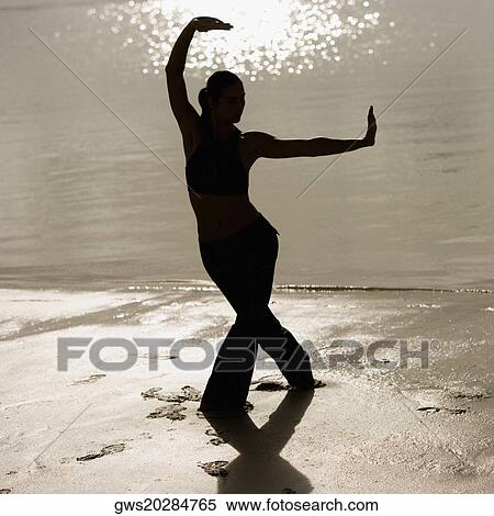 Silhouette of a mid adult woman exercising on the beach View Large Photo Image Stock Photography - Silhouette of a mid adult woman exercising on the beach. Fotosearch