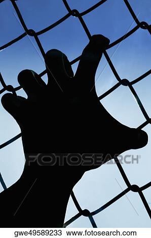 Stock Image - Silhouette of a person's hand holding a net. Fotosearch