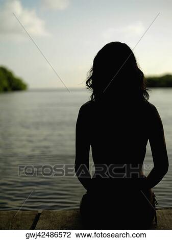 Silhouette of a young woman by the sea View Large Photo Image Stock Image - Silhouette of a young woman by the sea. Fotosearch