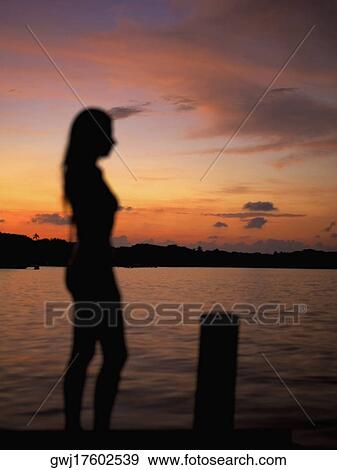 Silhouette of a young woman by the sea View Large Photo Image Stock Photo - Silhouette of a young woman by the sea. Fotosearch