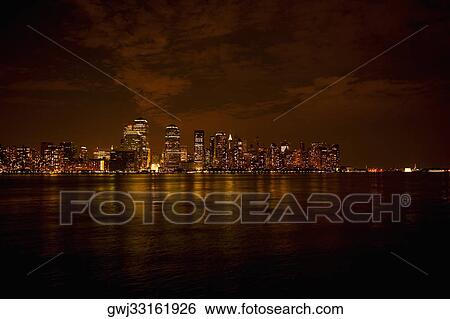 Skyscrapers at the waterfront lit up at night, New York City, New York State, USA View Large Photo Image Stock Photograph - Skyscrapers at the waterfront lit up at night, New York City, New York State, USA. Fotosearch