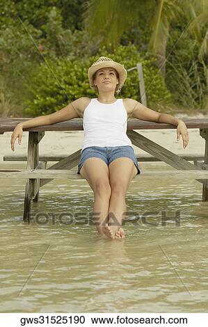 Stock Image - Teenage girl sitting on a bench. Fotosearch