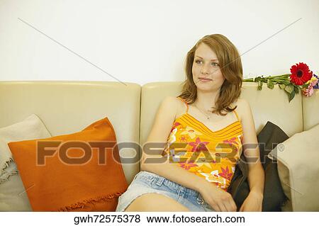 Teenage girl sitting on a couch View Large Photo Image Stock Photo - Teenage girl sitting on a couch. Fotosearch
