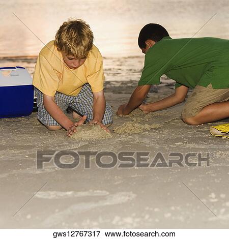 Two boys making sand castles View Large Photo Image Stock Photo - Two boys making sand castles. Fotosearch