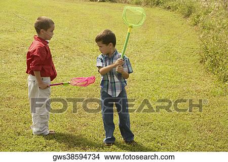 Two boys standing on the lawn and holding butterfly nets View Large Photo Image Picture - Two boys standing on the lawn and holding butterfly nets. Fotosearch