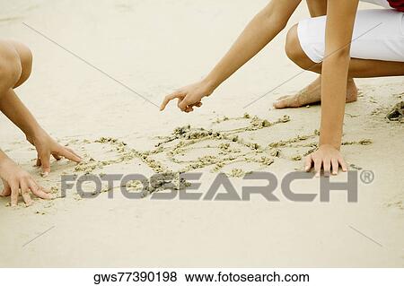 Stock Photo - Two girls drawing in sand. Fotosearch