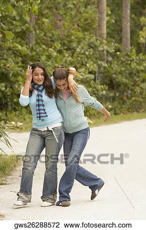 Stock Image - Two girls with their arms around each other. Fotosearch