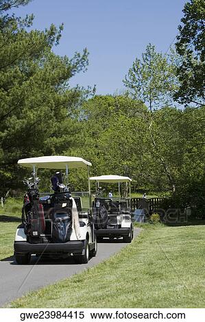 Two golf carts on a path View Large Photo Image Stock Photography - Two golf carts on a path. Fotosearch