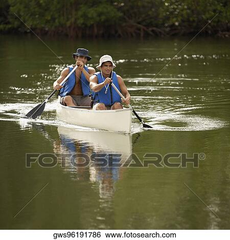 Stock Photograph - Two mid adult men canoeing. Fotosearch