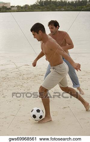Two mid adult men playing soccer on the beach View Large Photo Image Stock Image - Two mid adult men playing soccer on the beach. Fotosearch