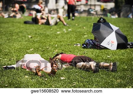Stock Image - Two people lying down in the park. Fotosearch