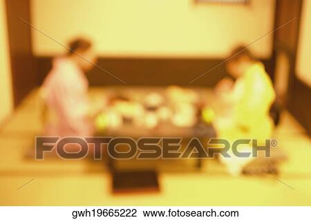 Stock Image - Two women wearing Kimonos and sitting together, Tokyo, Japan. Fotosearch