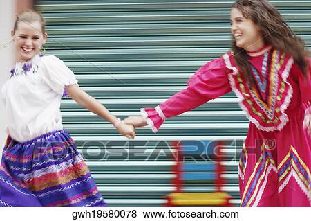 Two young women holding hands and walking View Large Photo Image Stock Photo - Two young women holding hands and walking. Fotosearch