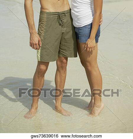 Young man and a teenage girl standing on the beach View Large Photo Image Stock Photograph - Young man and a teenage girl standing on the beach. Fotosearch