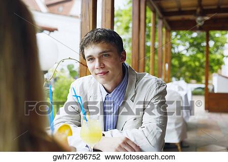 Young man and a woman sitting in a restaurant View Large Photo Image Stock Image - Young man and a woman sitting in a restaurant . Fotosearch