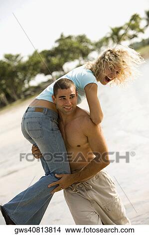 Young man carrying a young woman on his shoulders View Large Photo Image Picture - Young man carrying a young woman on his shoulders. Fotosearch