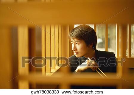 Young man holding chopsticks View Large Photo Image Stock Image - Young man holding chopsticks. Fotosearch