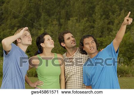 Young man pointing up to his friends View Large Photo Image Stock Image - Young man pointing up to his friends. Fotosearch