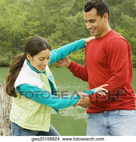 Young man standing and holding a young woman's hands View Large Photo Image Picture - Young man standing and holding a young woman's hands. Fotosearch