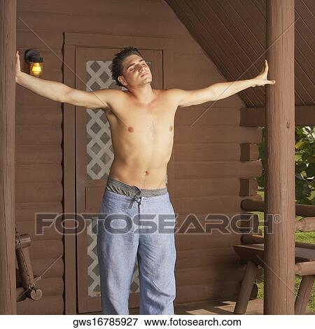 Stock Photo - Young man standing with his arms outstretched. Fotosearch