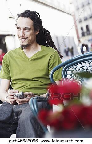 Young man using a mobile phone View Large Photo Image Stock Photograph - Young man using a mobile phone . Fotosearch