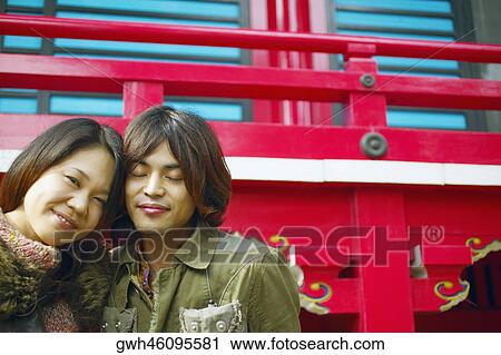 Stock Image - Young woman and a mid adult man sitting together . Fotosearch