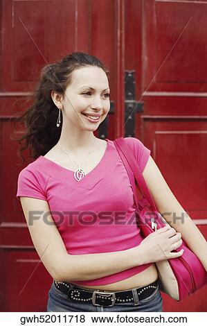 Young woman carrying a bag on her shoulder View Large Photo Image Stock Photo - Young woman carrying a bag on her shoulder. Fotosearch