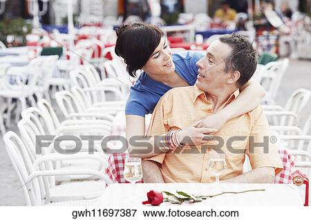 Young woman embracing a mature man from behind View Large Photo Image Stock Photo - Young woman embracing a mature man from behind . Fotosearch